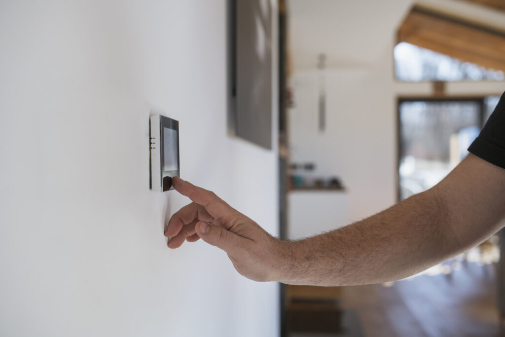 Man at home adjusting thermostat